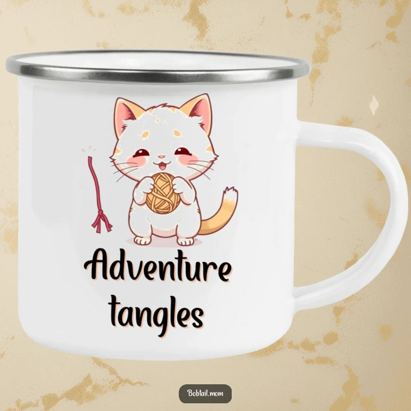Funny camping mug with a playful Bobtail cat batting at a dangling yarn ball, ready for outdoor fun.