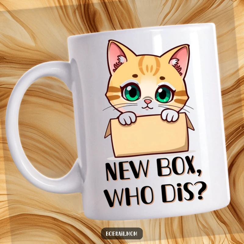 Funny Bobtail Cat Mug showing a curious cat with wide eyes peeking out from the opening of a cardboard box, conveying playful mischief.