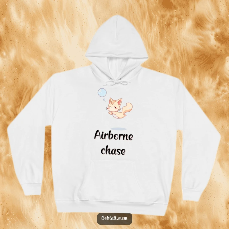 Funny Bobtail Hoodie illustrating a dog leaping joyfully to catch a floating bubble, perfect for active and playful moments.