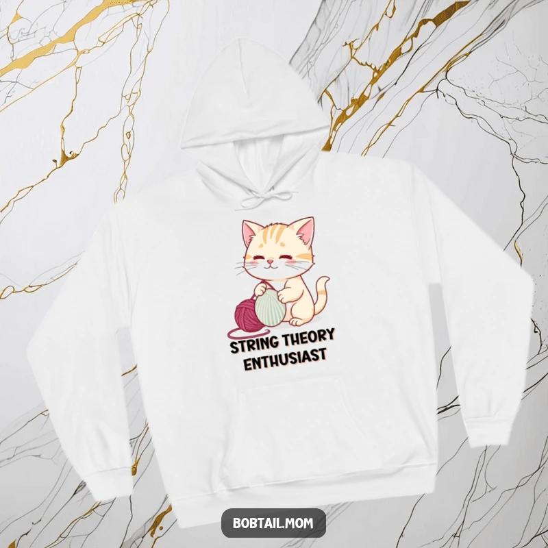 Funny bobtail cat tangled in yarn, playfully batting it around, looking cute and mischievous on a cozy hoodie.